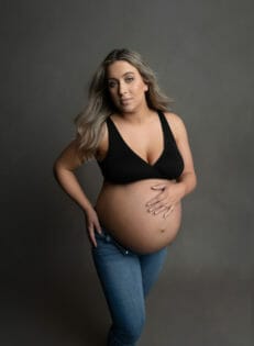 pregnant woman in jeans with black bra revitalized thanks to New Orleans prenatal massage spa