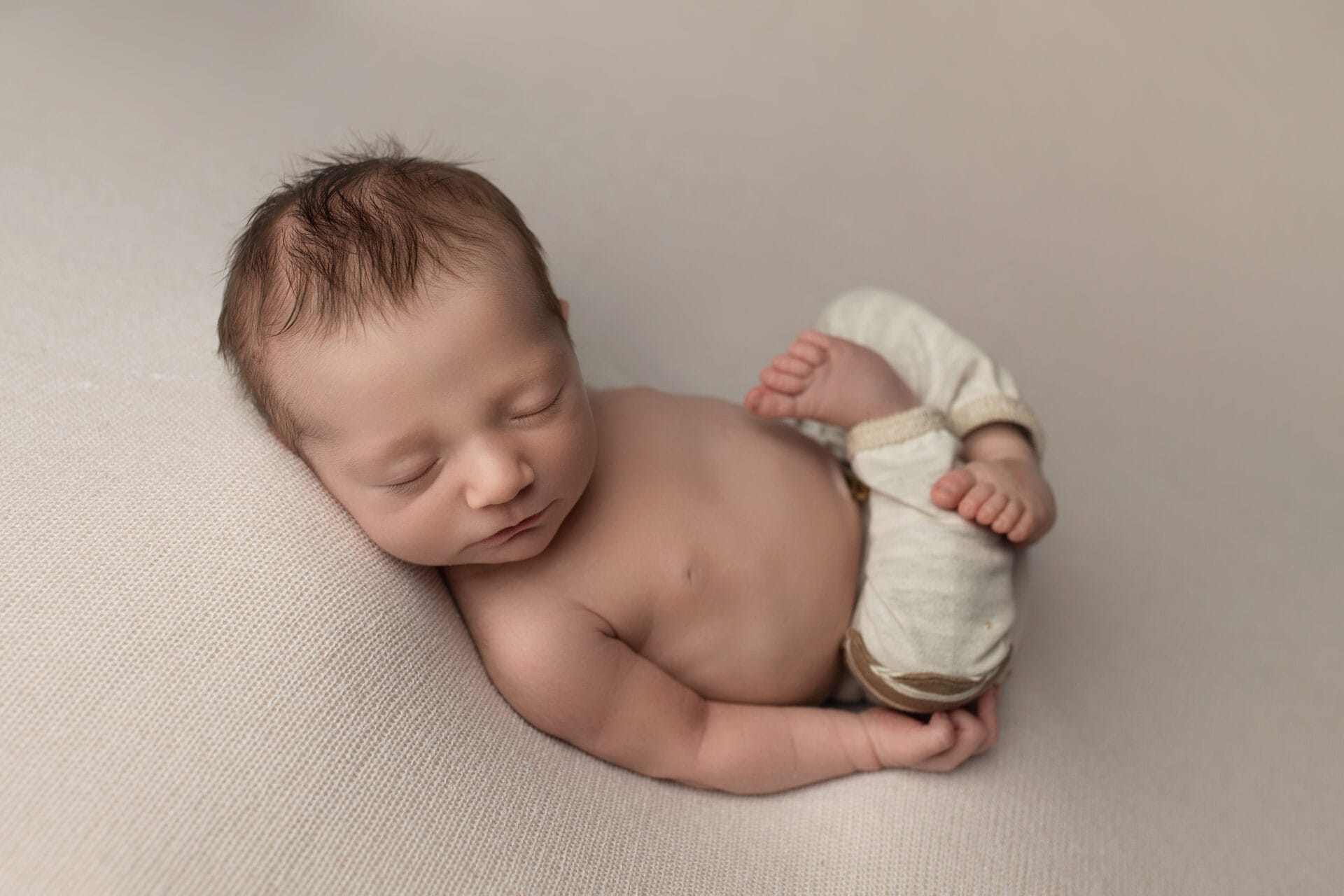 newborn baby boy sleepy in natural pose with New Orleans newborn photographer