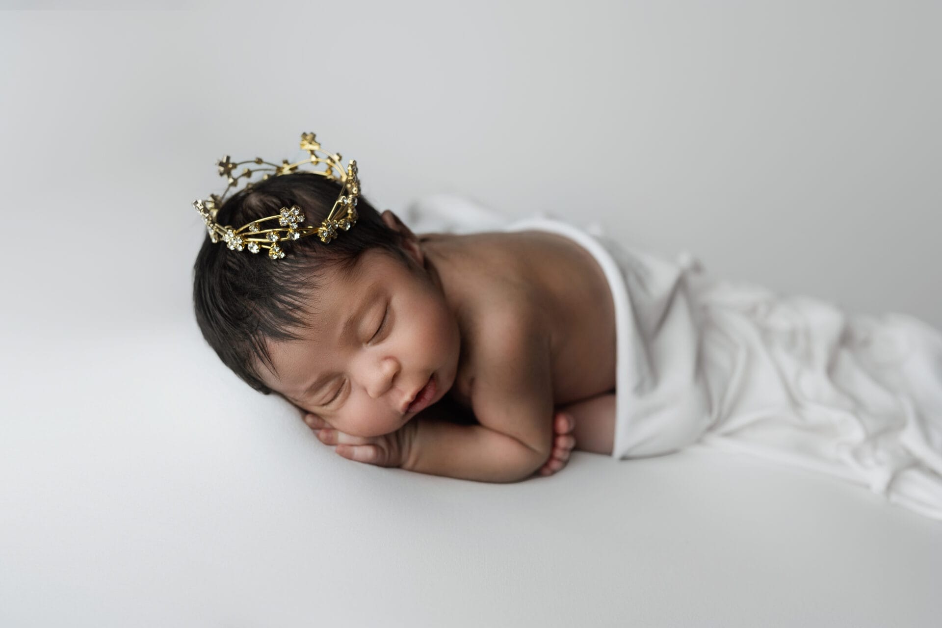 baby girl with gold crown smiling