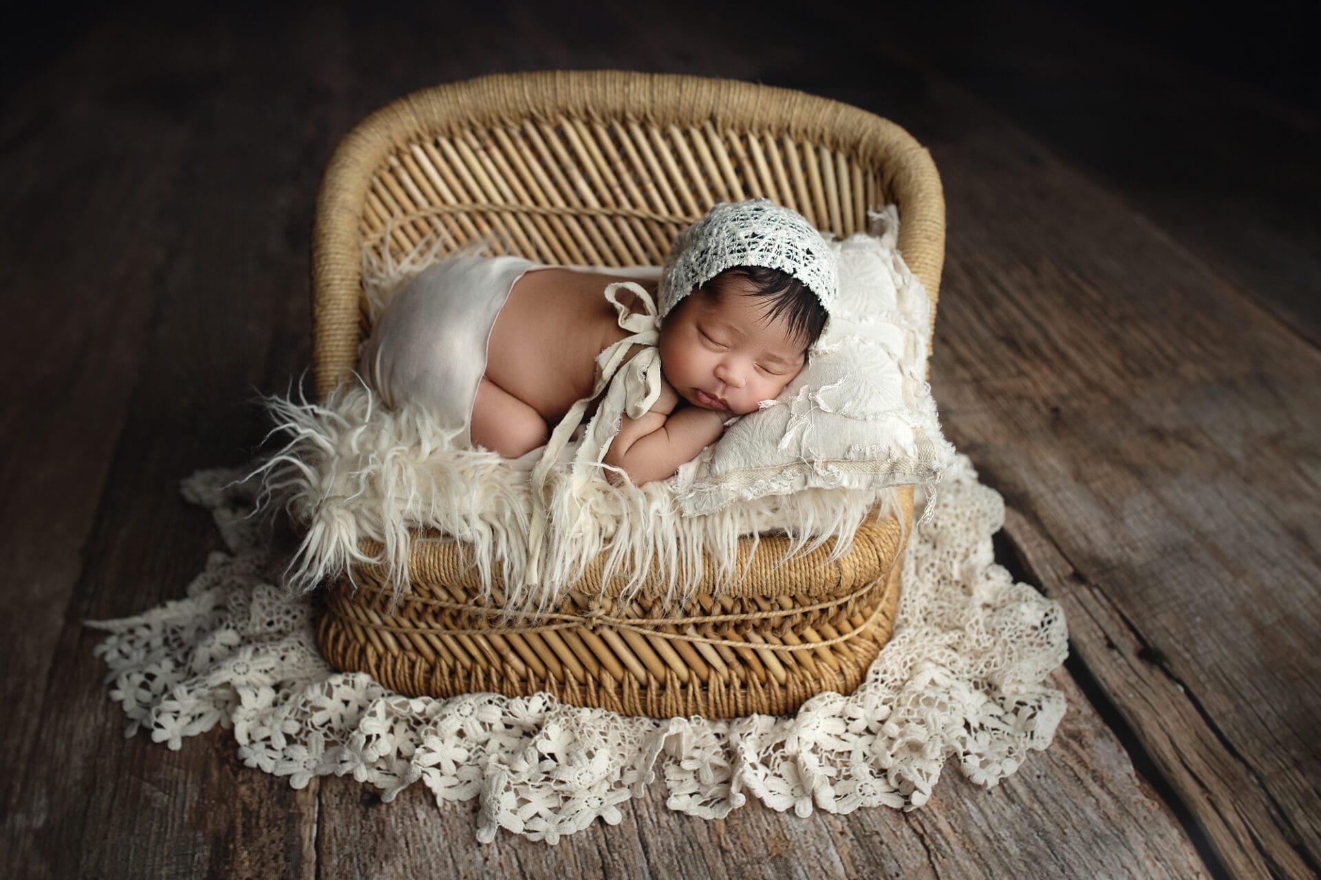 newborn baby girl in wicker bed boho layers