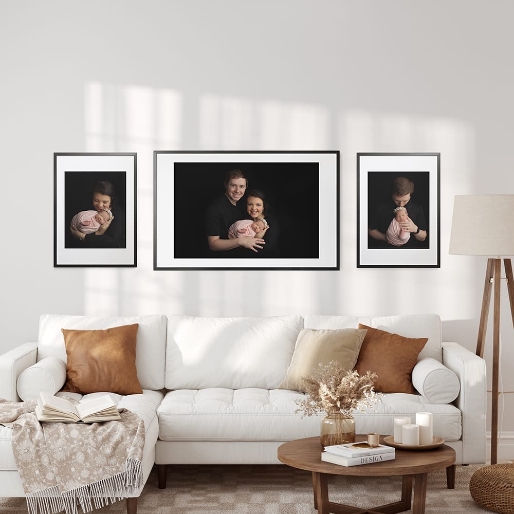 Photo of a living room with wall art with new parents with their baby girl with Baton Rouge newborn photographer. 