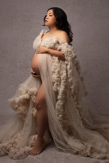 Photo of pregnant mom in tan flowy gown with New Orleans maternity photographer. 