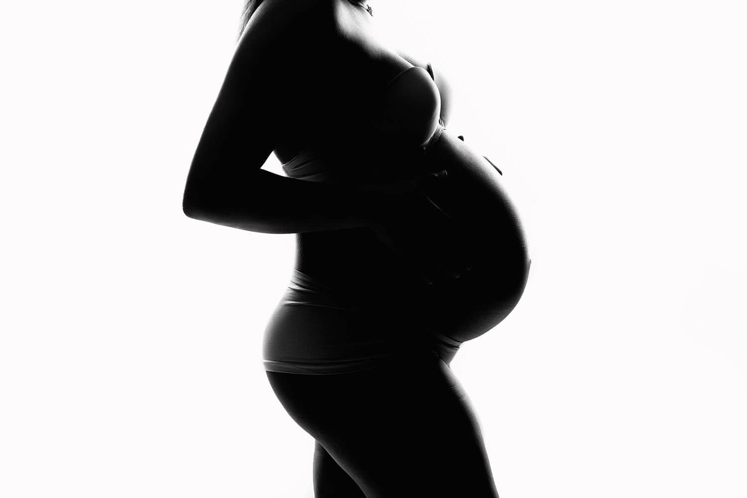 Silhouette of pregnancy mom to be belly in studio with Baton Rouge OBGYN.