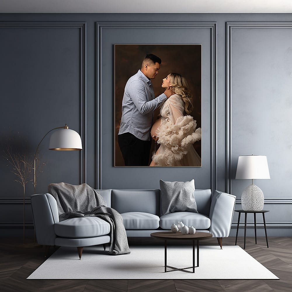A living room with wall art of an expecting couple embracing their pregnancy.